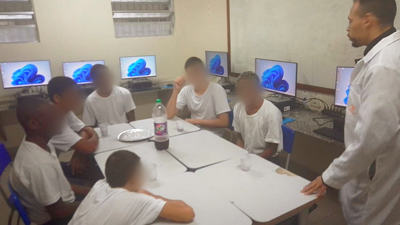 Jovens no laboratório de informática com o professor