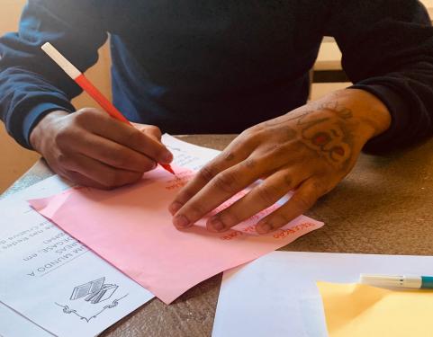 Menino escrevendo durante encontro do projeto