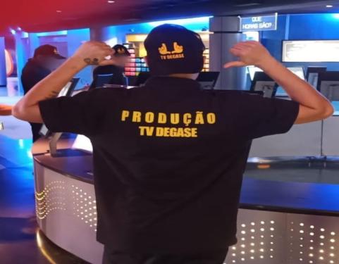 Jovem de costas com a blusa da TV Degase, no Planetário 