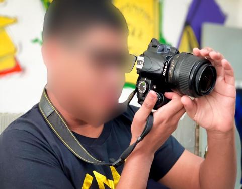 Adolescente segura câmera durante workshop de Fotografia