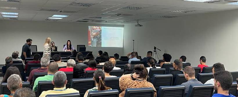 auditório com dezenas de pessoas sentadas 