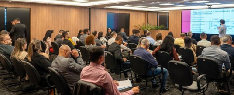 sala com pessoas assistindo palestras