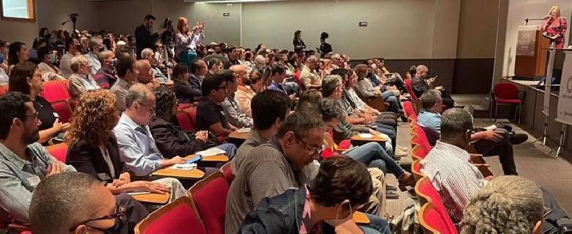 auditório com dezenas de pessoas sentadas