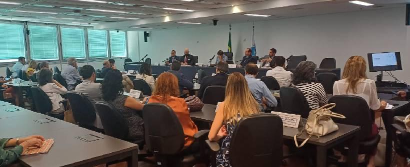 sala com pessoas assistindo audiência