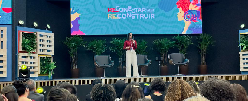 auditório com dezenas de pessoas sentadas 