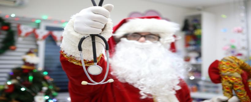 Médico do HEAT troca jaleco branco por barba branca e um saco cheio de presentes