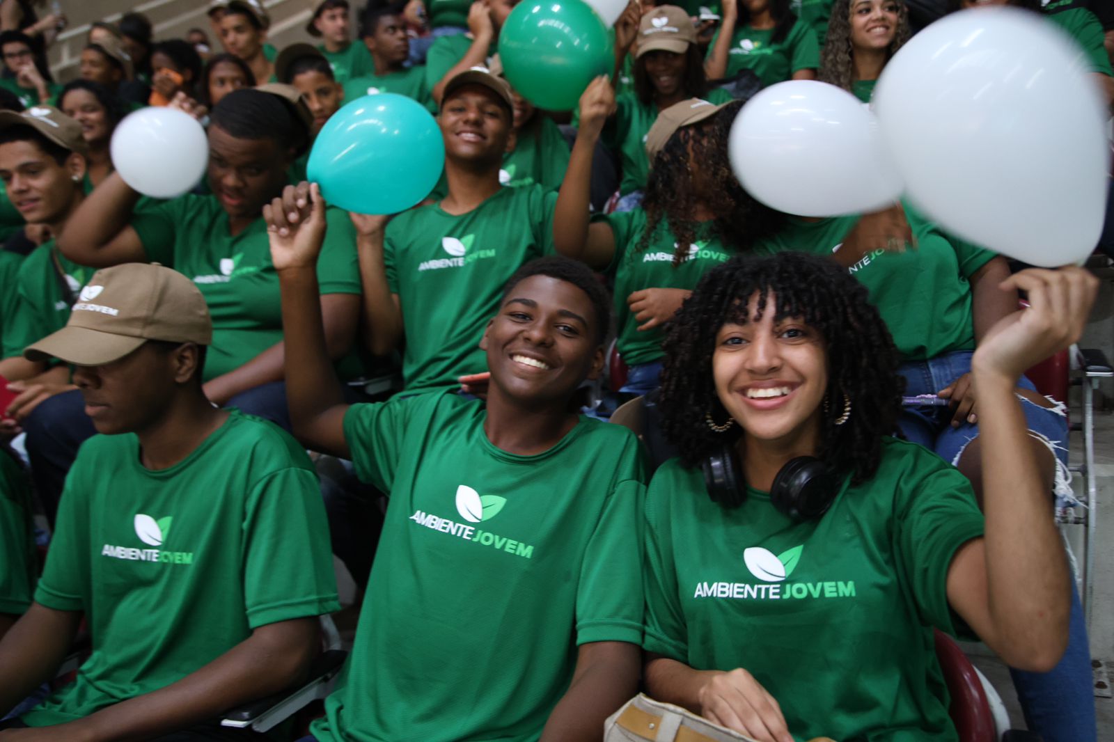 dois jovens segurando um balão branco sentados e sorrindo