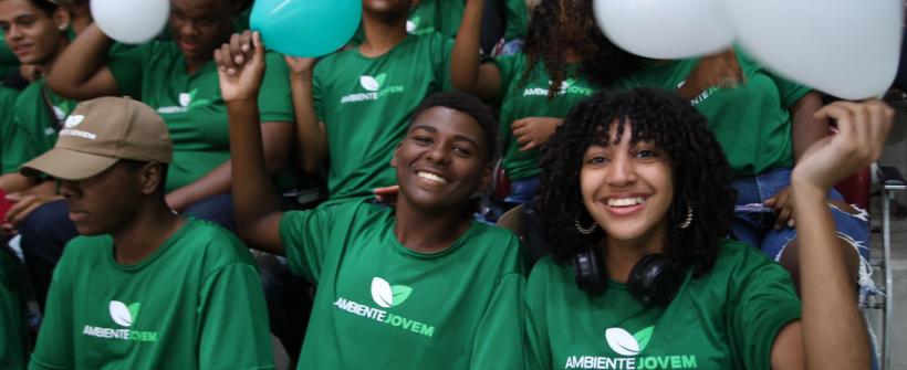 dois jovens segurando um balão branco sentados e sorrindo