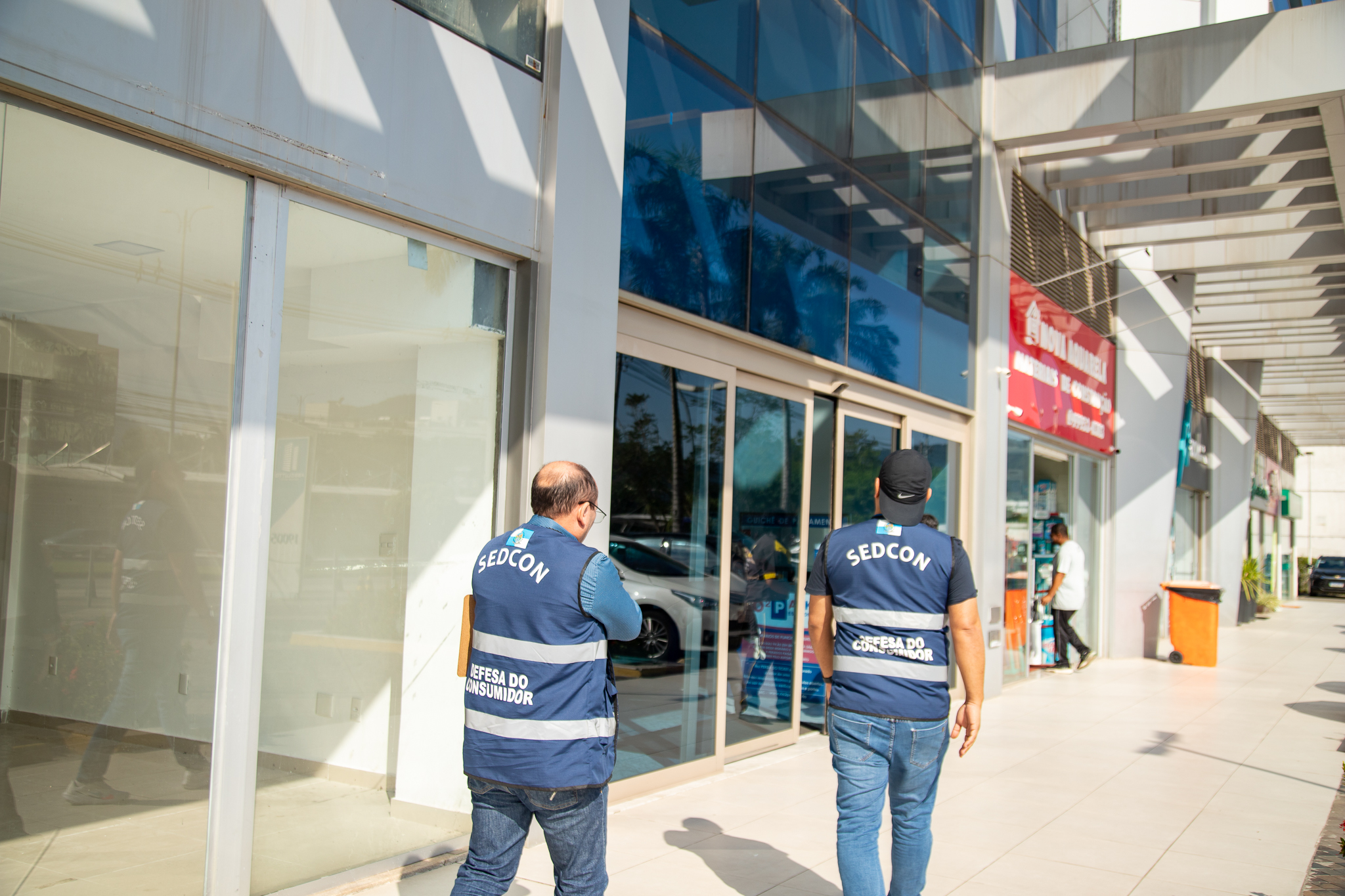 No dia 5 de julho, agentes da SEDCON autuaram uma cozinha e uma cafeteria instaladas de maneira clandestina em um prédio comercial no Recreio dos Bandeirantes. Os estabelecimentos funcionavam em conjunto e de maneira irregular em uma área de uso comum no play do prédio. Ambos foram fechados por irregularidades e falta de segurança. A diligência aconteceu graças a denúncias enviadas ao canal de atendimento ao Consumidor da Secretaria, o Fala Consumidor. Ocupantes de salas comerciais no prédio relataram à Secretaria que o recinto foi transformado de maneira improvisada em uma cozinha, o que além de ferir a legislação pelo uso indevido do local, não é permitido por colocar a segurança dos demais condôminos em risco. Havia falta de exaustores, com a presença de fogão a gás e sem equipamentos adequados, o que colocava vidas em risco. Além disso, o cheiro de comida tomava conta do prédio o dia inteiro, incomodando a todos. A equipe da SEDCON encontrou também a cozinha clandestina em péssimas condições de higiene e com alimentos mal acondicionados, em potes sem identificação ou data de validade. A cafeteria que funcionava no mesmo andar do prédio era abastecida pela cozinha, e ali também foram encontradas irregularidades, como alimentos vencidos e armazenados de maneira imprópria, arriscando a saúde de consumidores. Nem a cafeteria e nem a cozinha possuíam alvarás de funcionamento e em ambos os locais, os agentes encontraram cerca de 20kg de produtos vencidos ou sem prazo de validade, que foram descartados de maneira voluntária pelos funcionários. “E aqui fica o alerta da secretaria de estado de defesa do consumidor quanto a esse tipo de estabelecimento que representa um risco que vai além da relação de consumo: é um risco pra vida dos consumidores por estarem expostos a uma alimentação sem as condições adequadas de higiene” – declarou o Subsecretário de Defesa do Consumidor, Alessandro Carracena, que acompanhou a diligência. Foi lavrado Auto de Constatação e Notificação pela SEDCON e entregue aos responsáveis: o