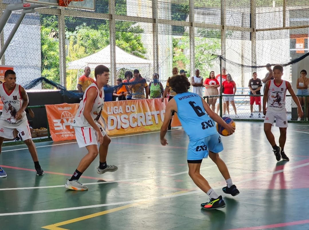 Jovens com uniformes de basquete, jogando em uma quadra.