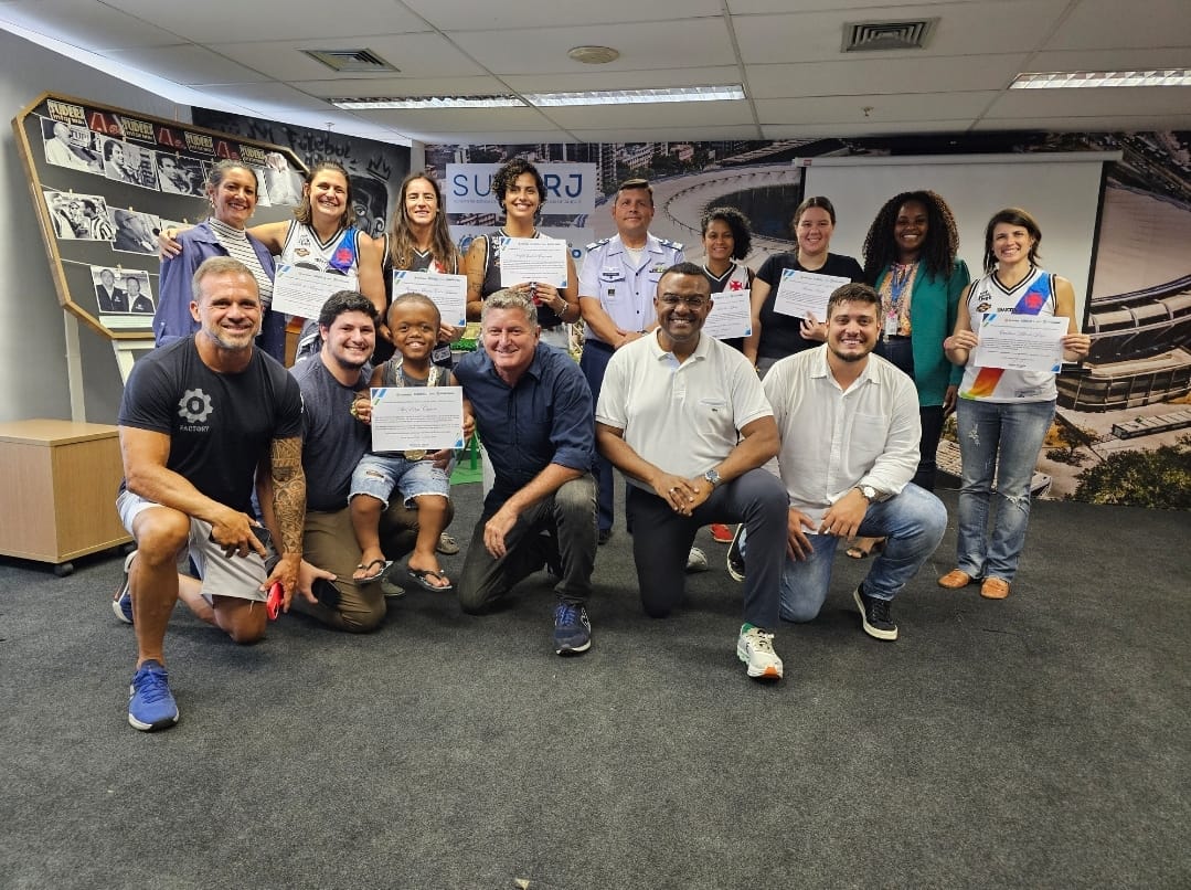 Grupo reunido com certificados nas mãos, sorrindo para foto